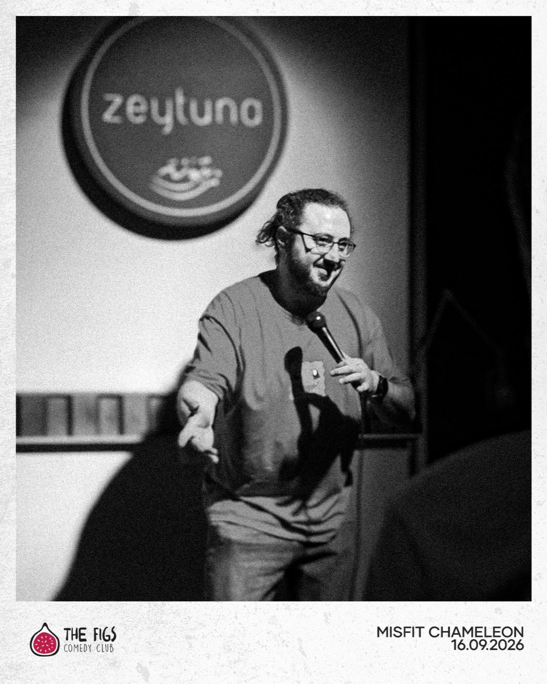 Misfit Chameleon gesturing to the crowd mid-joke
