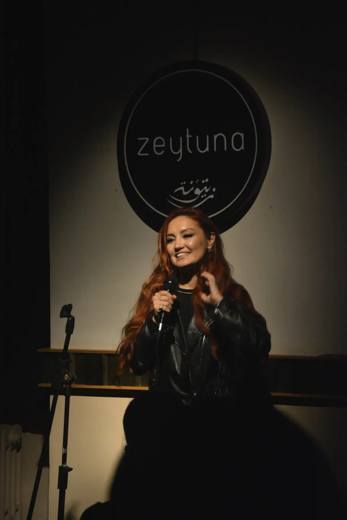 Karina on stage under the Zeytuna sign