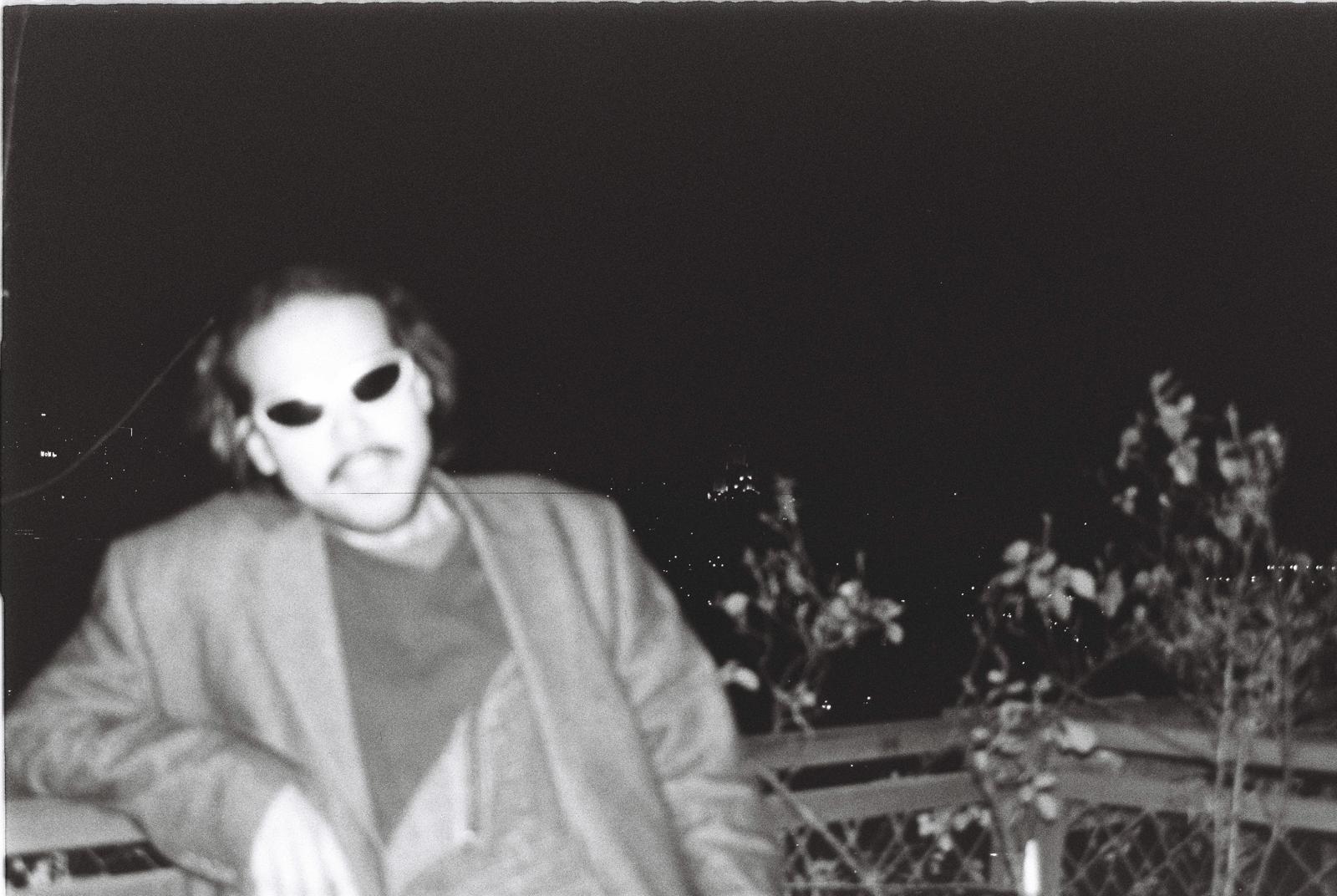 Black-and-white film photo of Selah Ucla in sunglasses at night