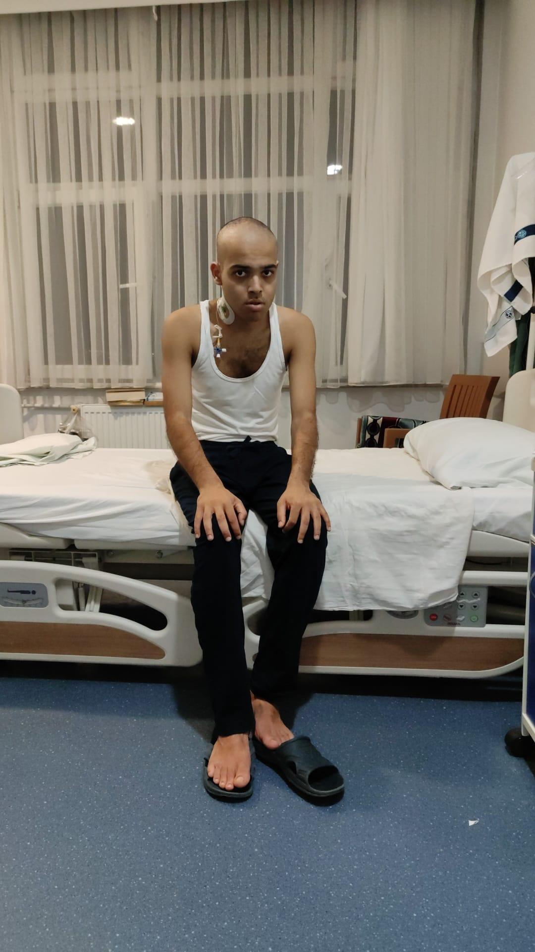 Selah Ucla sitting on a hospital bed during cancer treatment