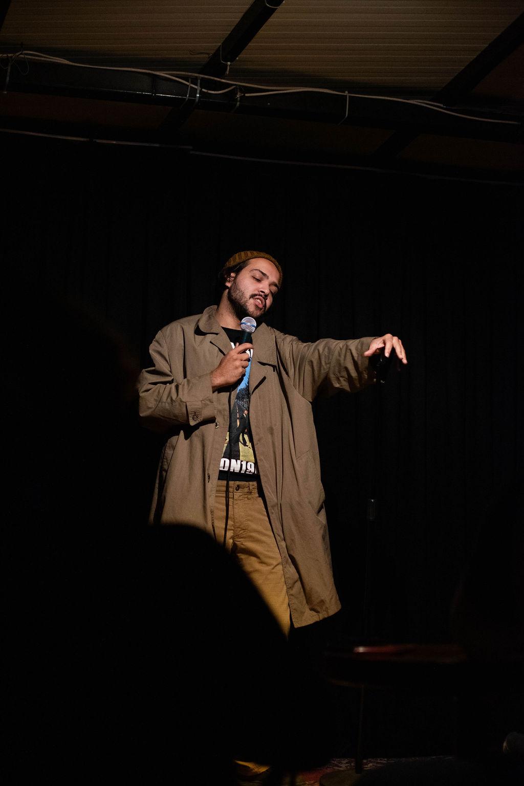 Selah Ucla performing in a long coat, eyes closed