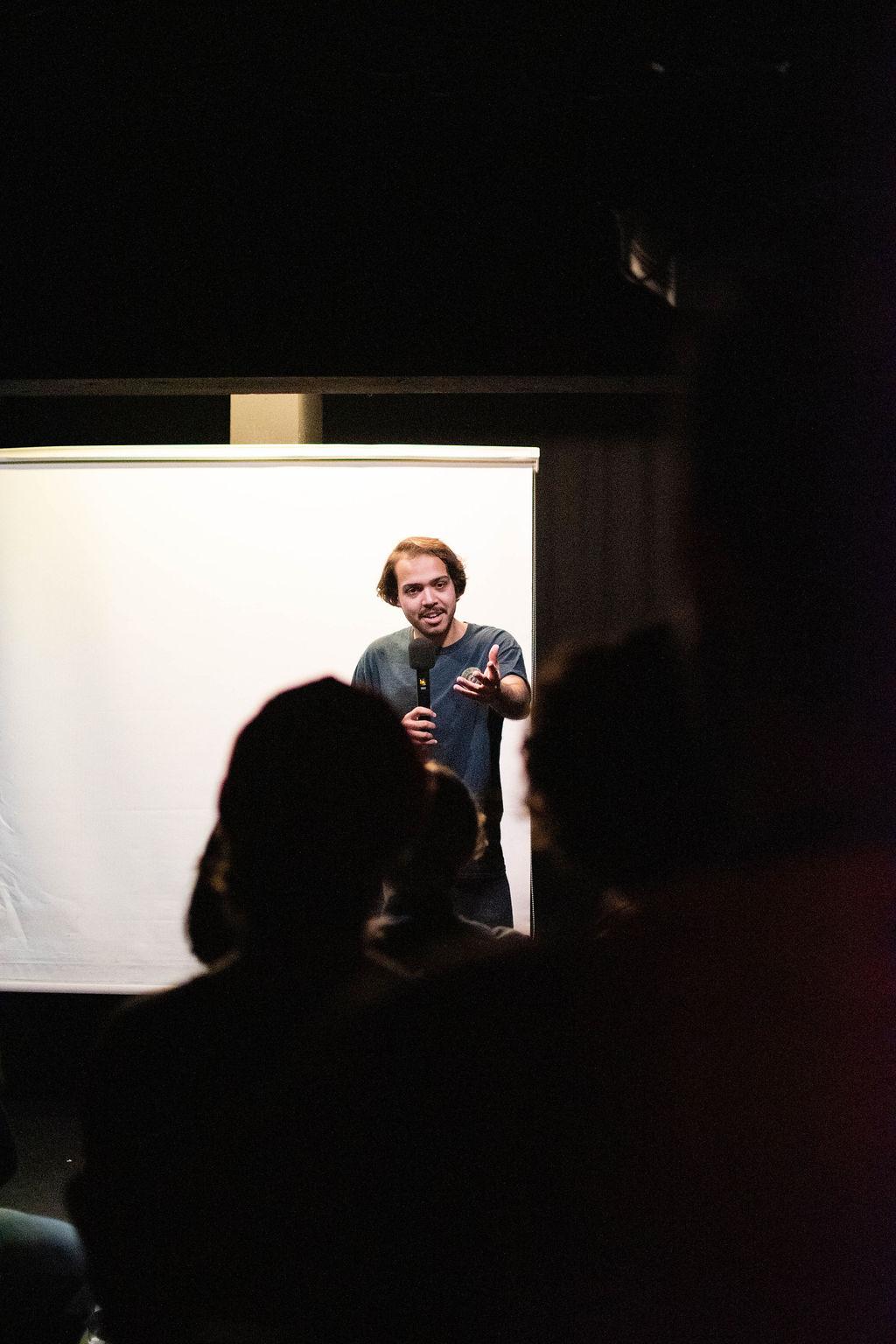 Selah Ucla performing to a crowd seen in silhouette